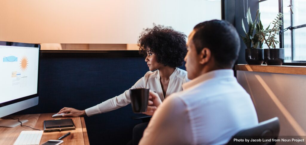 Two businesspeople looking together at computer